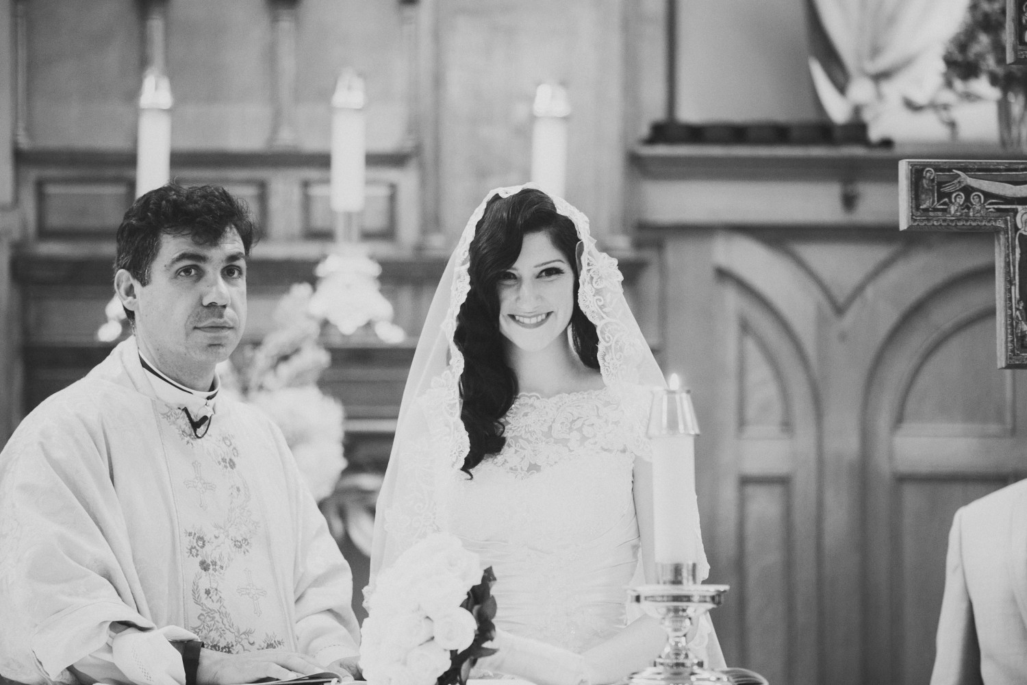 Black and white portrait of the bride smiling during the wedding ceremony.