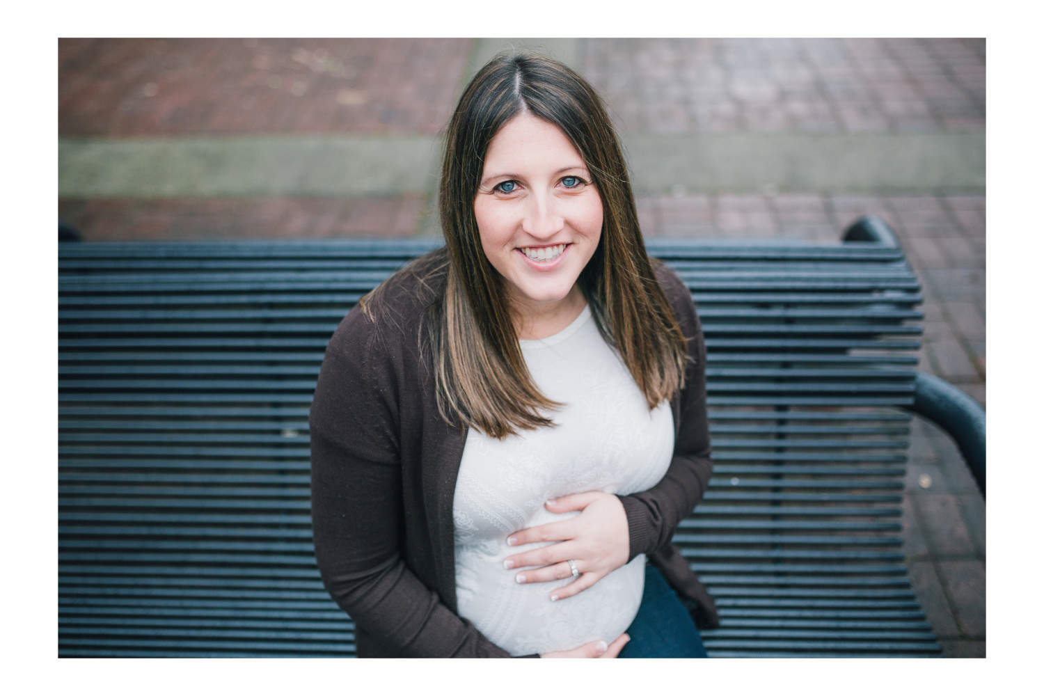 Mother to be sitting on a bench during Vancouver maternity session.