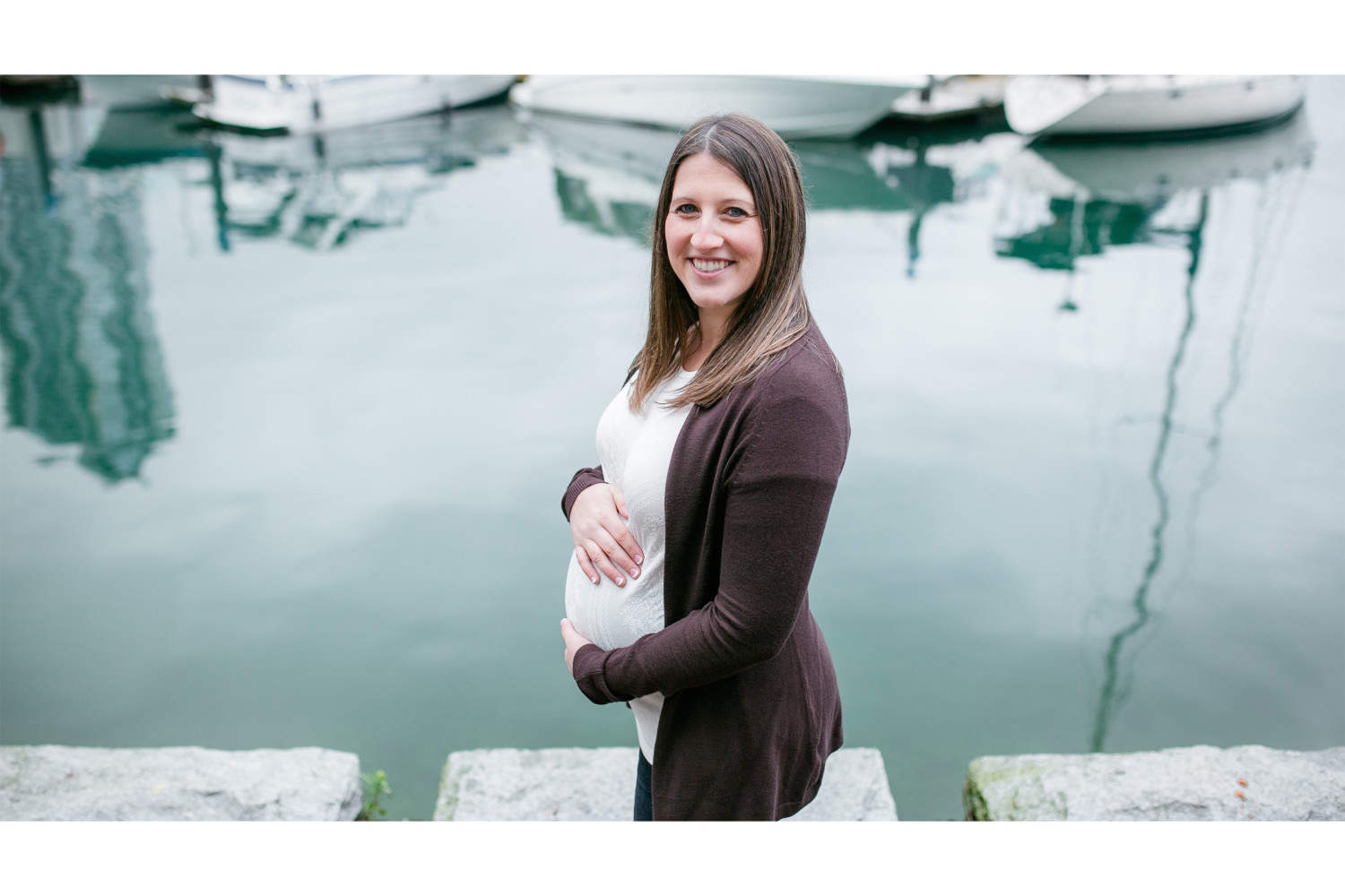 Mother to be standing beside water during Vancouver maternity session.