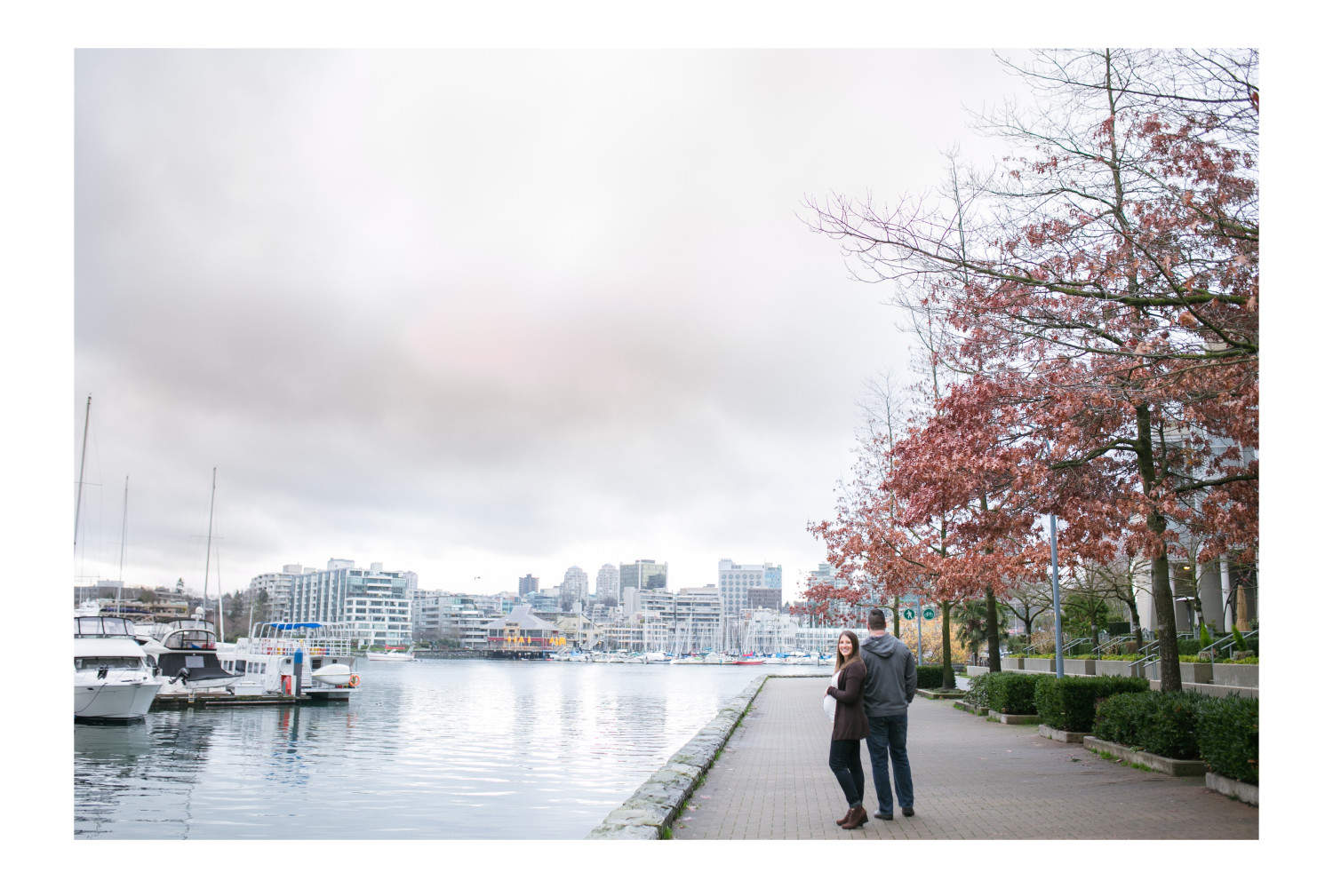 Couple walking along seawall during Vancouver maternity session.