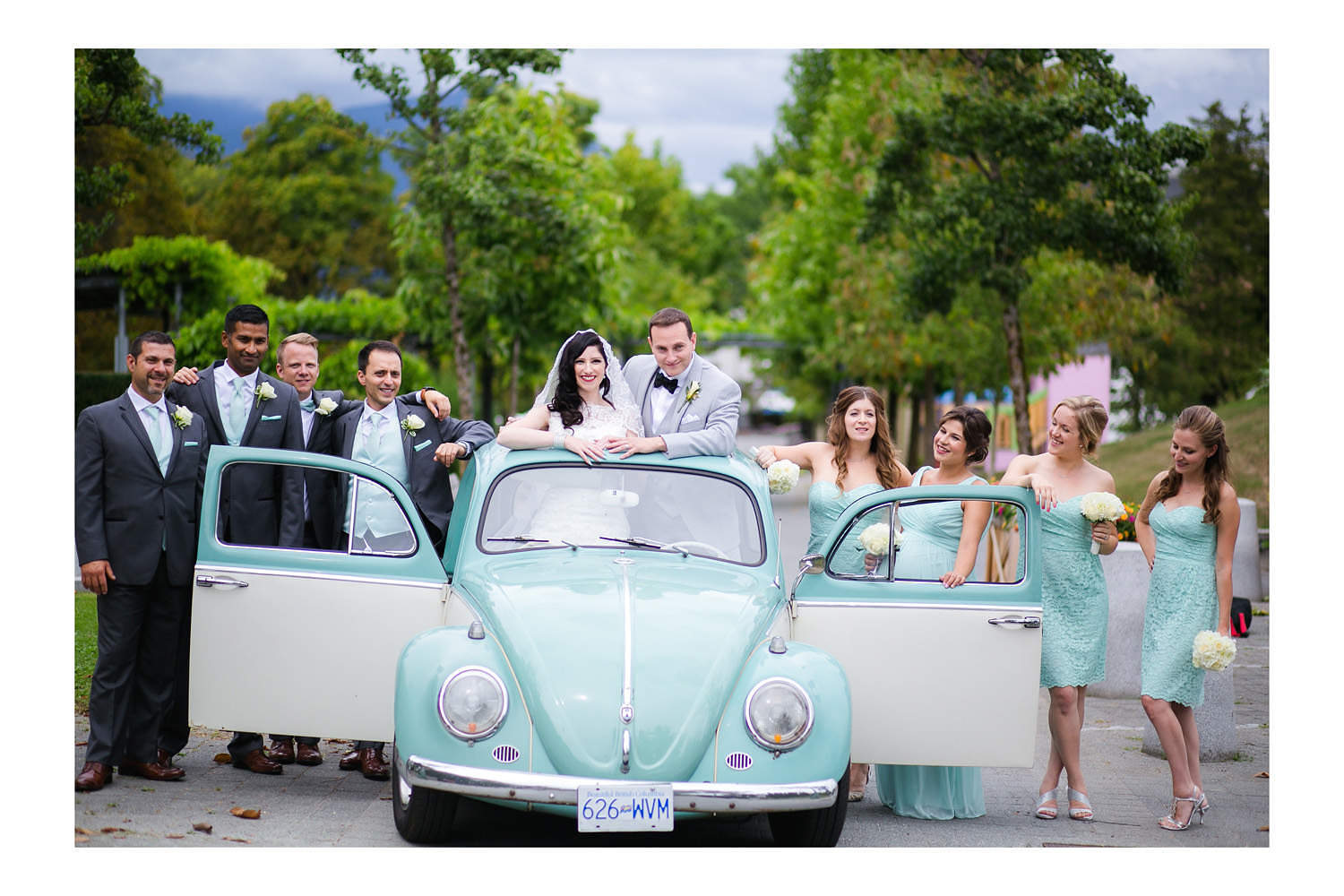 Bridal party posing with old VW Beetle at Hastings Gardens in Vancouver.