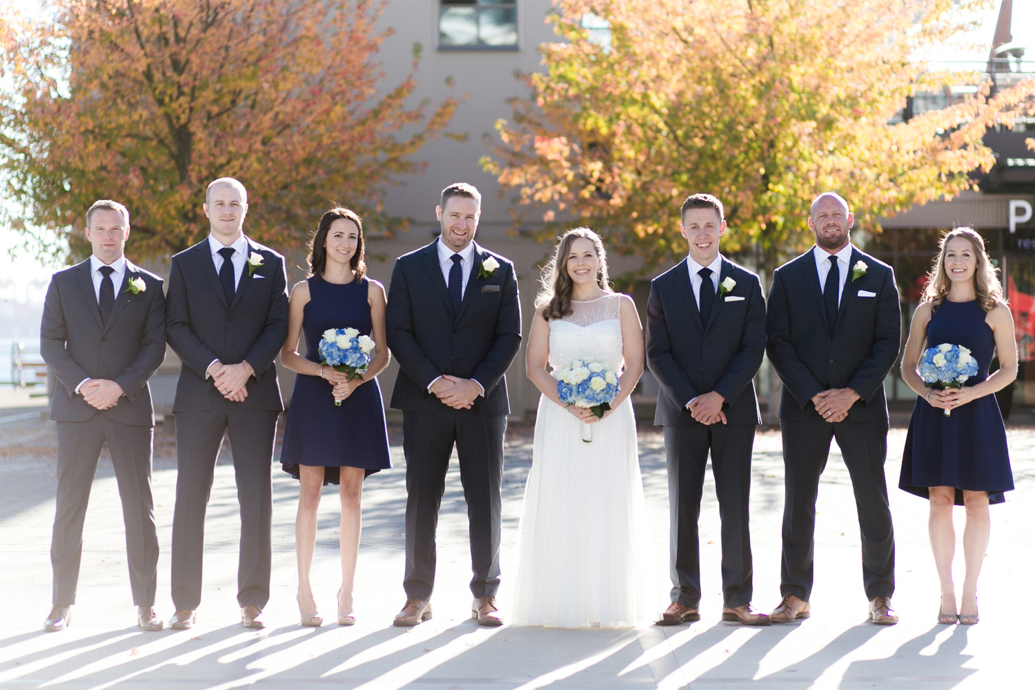 Bridal party posing in front of Pier 7 during bridal party shots in Fall wedding.