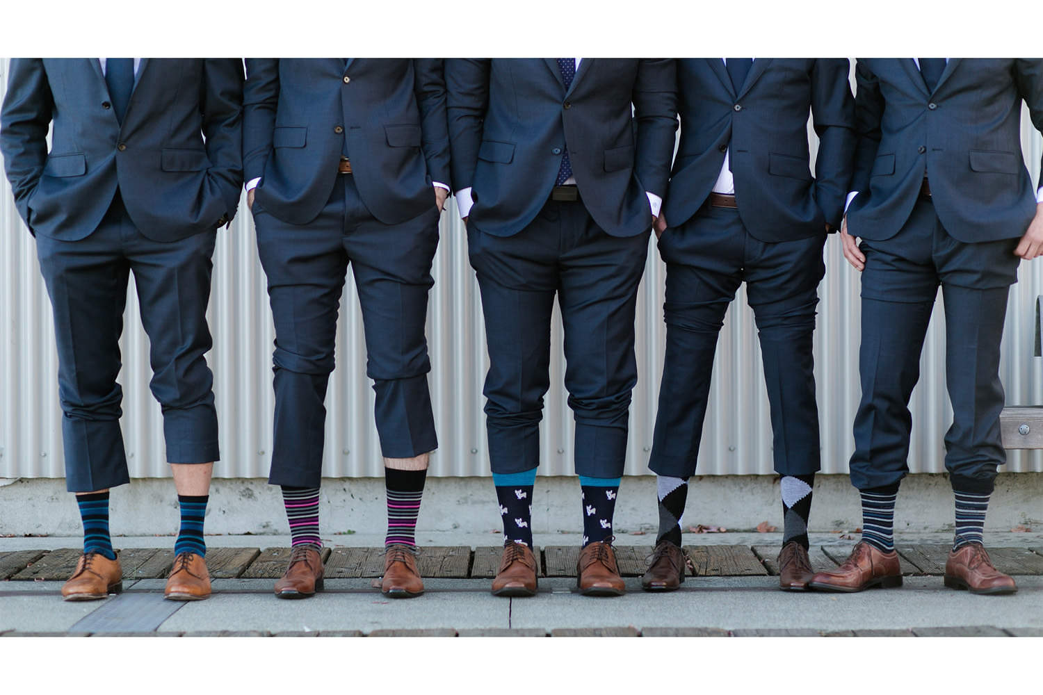 Groomsmen showing colourful socks during bridal party photos.