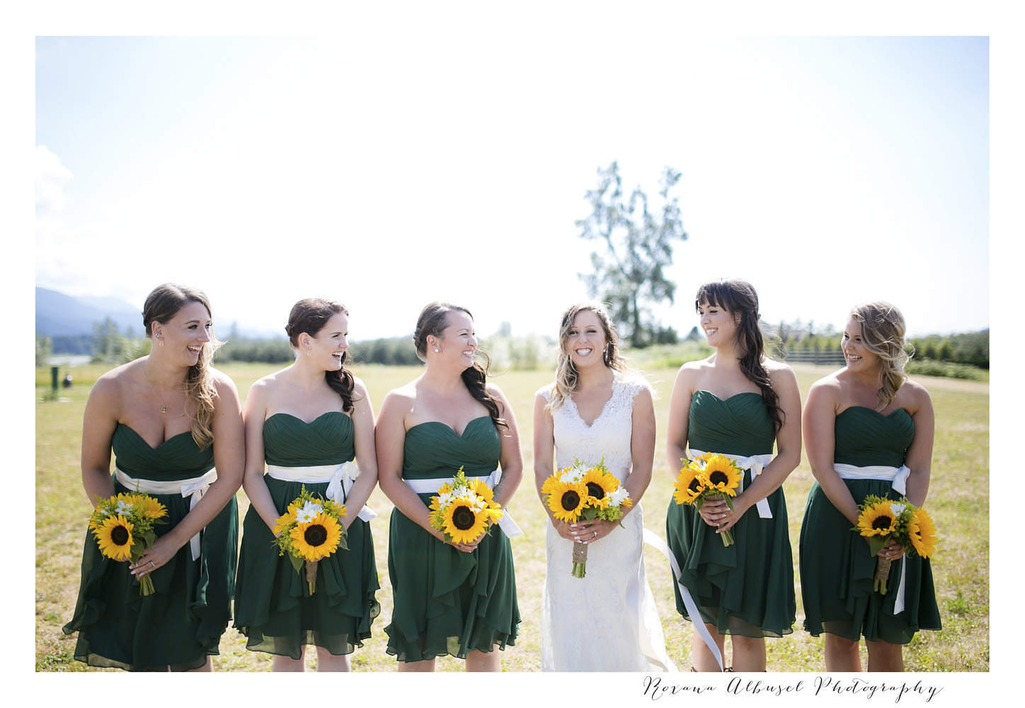 Bridesmaids posing with bouquets and smiling at Fraser River Fishing Lodge.