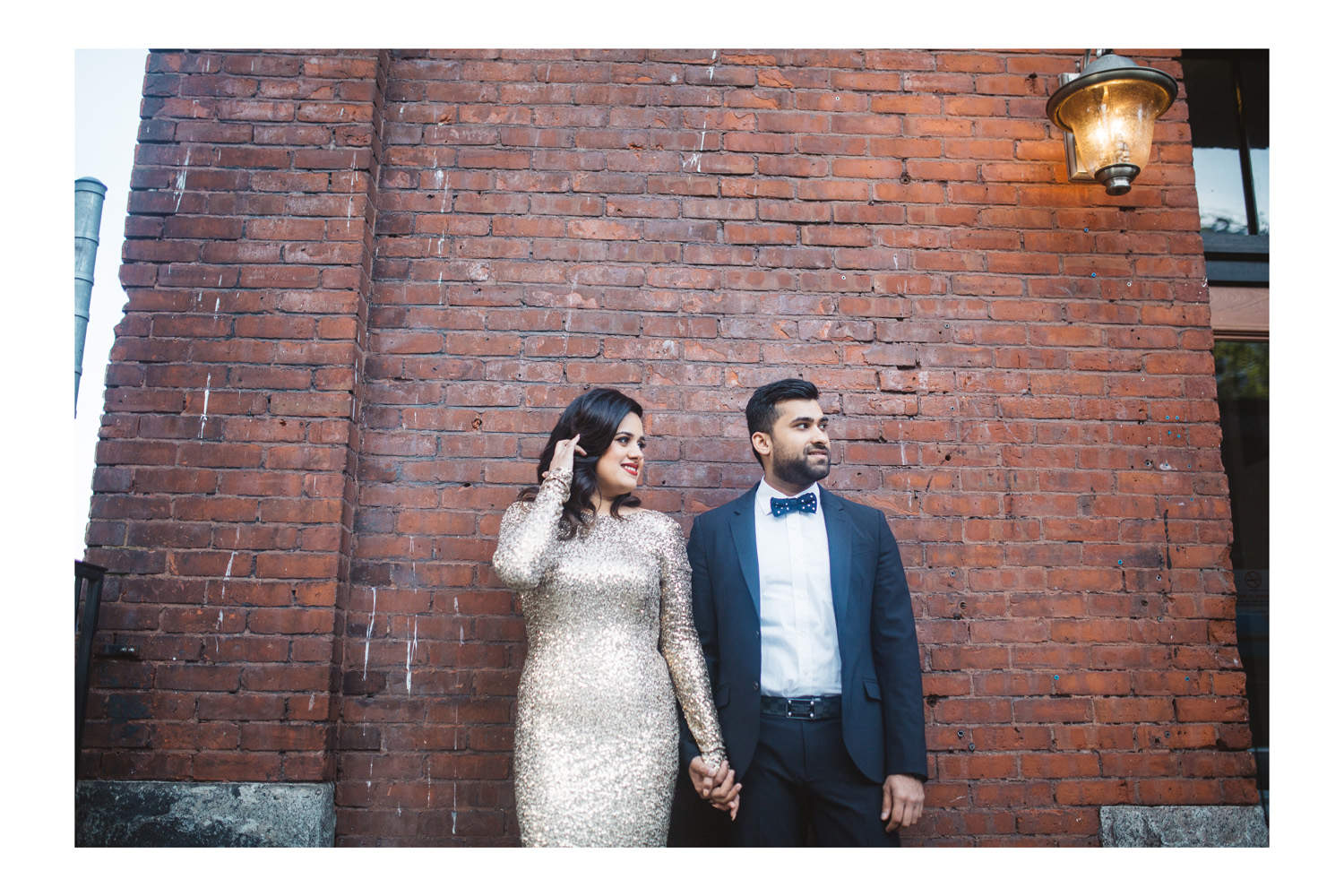 Gastown engagement photography against brick wall.
