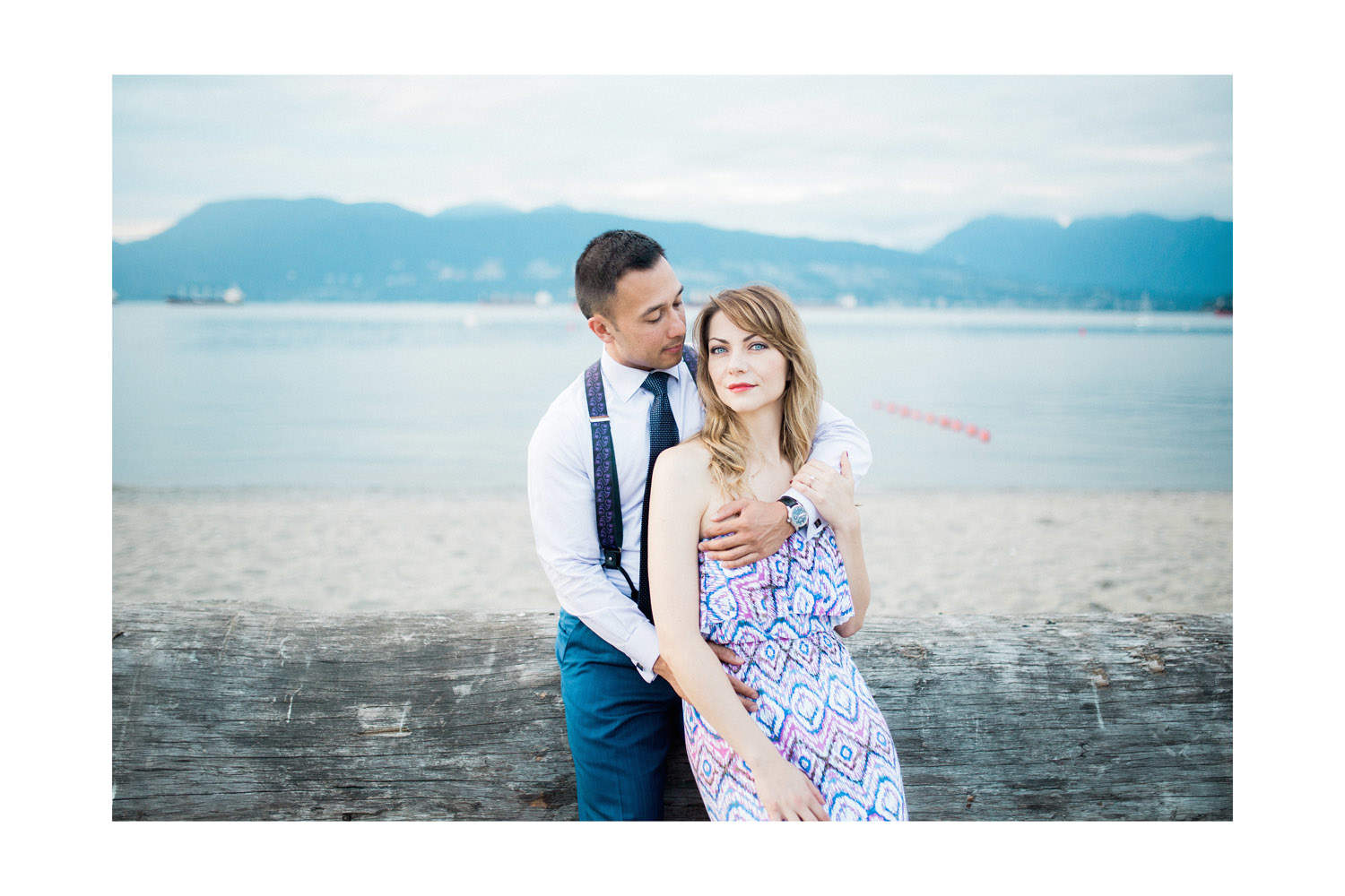 couple on log during engagement session at jericho beach